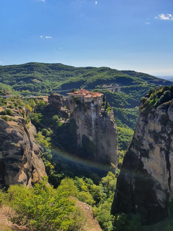 A monastery balanced on a sheer sandstone pillar at Meteora, with steps cut into the rock leading up